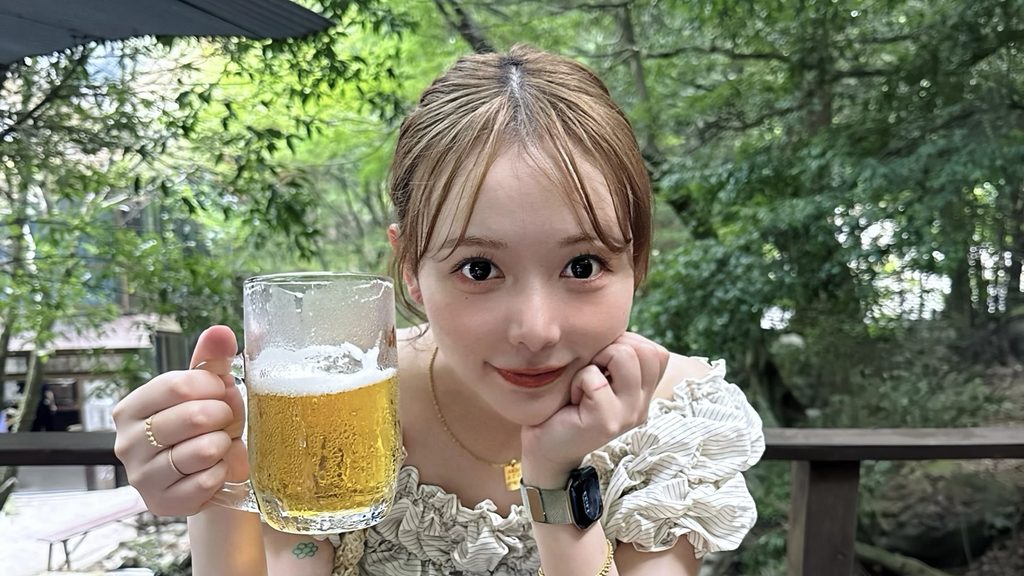 緑に囲まれた屋外で大好きなビールを楽しむ現在のあちもん